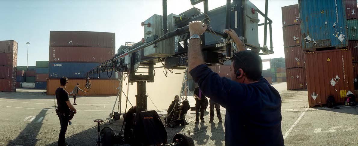 A techno crane rigged among shipping containers